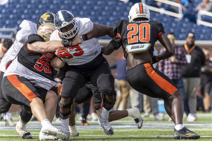 Feb 1, 2024; Mobile, AL, USA; American offensive lineman Christian Haynes of UConn (63) battles with American defensive lineman Braden Fiske of Florida State (55) and American linebacker James Williams of Miami (20) during practice for the American team at Hancock Whitney Stadium. Mandatory Credit: Vasha Hunt-USA TODAY Sports